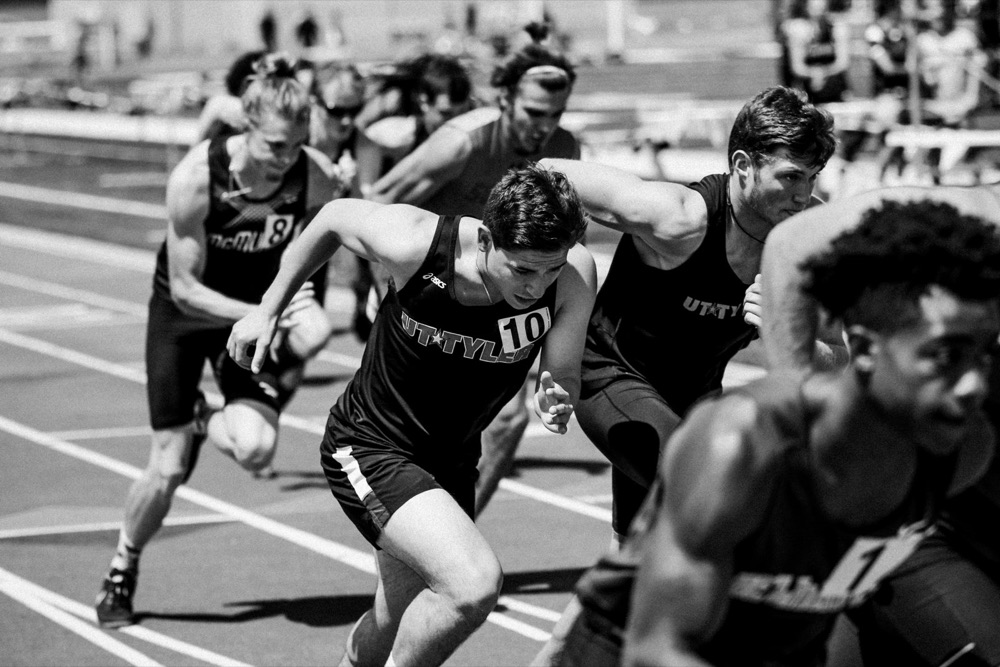 Sprinters driving out of the start of a track race